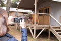 Woman makes a picture of her wooden rental cottage with phone Royalty Free Stock Photo