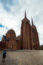 A woman makes a video of the exterior of The Cathedral of Saint Luke in Roskilde, Denmark, with a gimbal standcam for smartphone