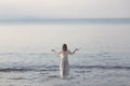 Woman makes yoga exercises in front of ocean