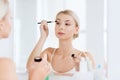 Woman with makeup brush and eyeshade at bathroom Royalty Free Stock Photo