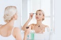 Woman with makeup brush and eyeshade at bathroom Royalty Free Stock Photo