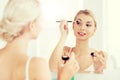 Woman with makeup brush and eyeshade at bathroom Royalty Free Stock Photo