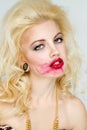 Woman with makeup smearing lipstick.