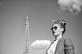 Woman with makeup and sunglasses in front of blue sky and top of Eiffel Tower on background. Stylish Parisian concept Royalty Free Stock Photo