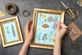 Woman making beautiful herbarium with pressed dried flower at black table, top view Royalty Free Stock Photo