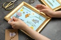 Woman making beautiful herbarium with pressed dried flower at black table, closeup Royalty Free Stock Photo