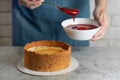 Woman making cheesecake, spoons out strawberry confiture, close up photo Royalty Free Stock Photo