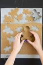 Woman making Christmas cookies on a black surface, top view. From above, overhead Royalty Free Stock Photo