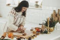 Woman making christmas gingerbread cookies in modern white kitchen. Hand kneading gingerbread dough on wooden board with flour, Royalty Free Stock Photo