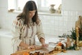 Woman making christmas gingerbread cookies in modern white kitchen. Hand kneading gingerbread dough on wooden board with flour, Royalty Free Stock Photo