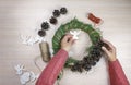 Woman making Christmas wreath and decorating it salt dough stars and angels