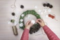 Woman making Christmas wreath and decorating it salt dough stars and angels