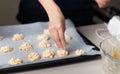 Woman making coconut cookies dough and aranging them on a pan covered with baking paper Royalty Free Stock Photo