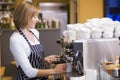 Woman making coffee in restaurant smiling Royalty Free Stock Photo