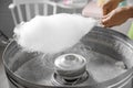 Woman making cotton candy using modern machine indoors Royalty Free Stock Photo