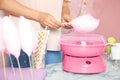 Woman making cotton candy using modern machine at table Royalty Free Stock Photo