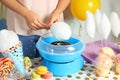 Woman making cotton candy using modern machine at table Royalty Free Stock Photo