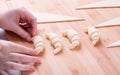 Woman is making croissants of puff pastry on wooden board Royalty Free Stock Photo