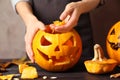 Woman making Halloween pumpkin head jack lantern on wooden table Royalty Free Stock Photo