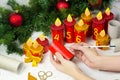 Woman making handmade advent calendar with toilet paper tubes at home. Girl Coloring rolls. Christmas candle craft. Royalty Free Stock Photo