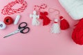 Woman making handmade traditional martisor, from red and white strings with tassel. Symbol of holiday 1 March, Martenitsa, Baba