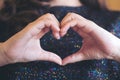 A woman making heart hand sign though her shirt