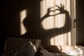 Woman making heart shadow with her hands on the wall. World mental health day, hope and love. Valentines 14 February Royalty Free Stock Photo