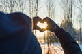 Woman making heart symbol with hands.sunny winter evening  sunrays  Valentines day  Love concept Royalty Free Stock Photo