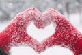 Woman making heart symbol with snowy hands