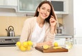 Woman making lemon water in kitchen