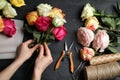 Woman making luxury bouquet of fresh roses at black table, top view Royalty Free Stock Photo