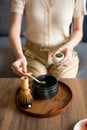 Woman making matcha green tea drink at home using tea ceremony set Royalty Free Stock Photo