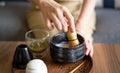 Woman making matcha green tea drink at home using tea ceremony set Royalty Free Stock Photo