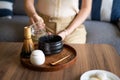 Woman making matcha green tea drink at home using tea ceremony set