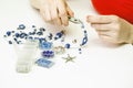 Woman making necklase from colorful plastic beads on light background