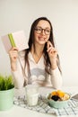 Woman making notes in notepad with healthy food on table Royalty Free Stock Photo