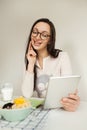 Woman making notes with tablet and healthy food on table Royalty Free Stock Photo