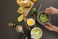 Woman making nourishing mask with avocado in kitchen