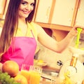 Woman making orange juice in juicer machine Royalty Free Stock Photo