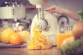 Woman making orange juice in juicer machine Royalty Free Stock Photo