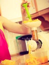 Woman making orange juice in juicer machine Royalty Free Stock Photo
