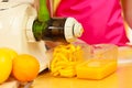 Woman making orange juice in juicer machine Royalty Free Stock Photo