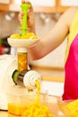 Woman making orange juice in juicer machine Royalty Free Stock Photo