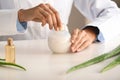 Woman making organic cosmetics with aloe in laboratory