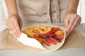 Woman making peach pie at kitchen table, closeup