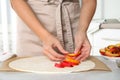 Woman making peach pie at kitchen table