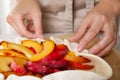 Woman making peach pie at table, closeup