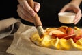 Woman making peach pie at table, closeup