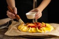 Woman making peach pie at wooden table, closeup