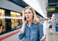 Woman making phone call at the underground platform, waiting Royalty Free Stock Photo